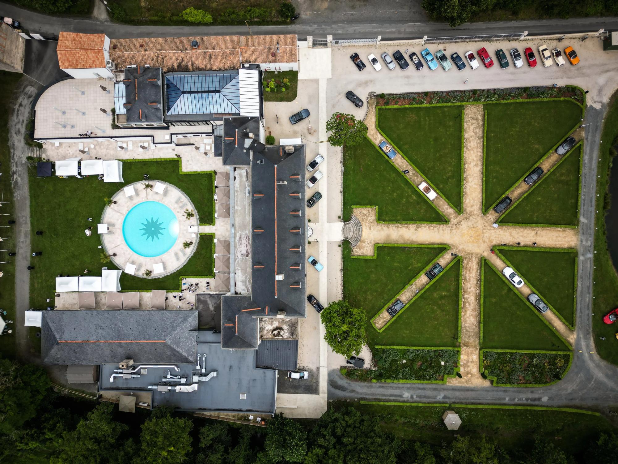 Vue aérienne de l'abbaye de Villeneuve, montrant la piscine et les jardins symétriques