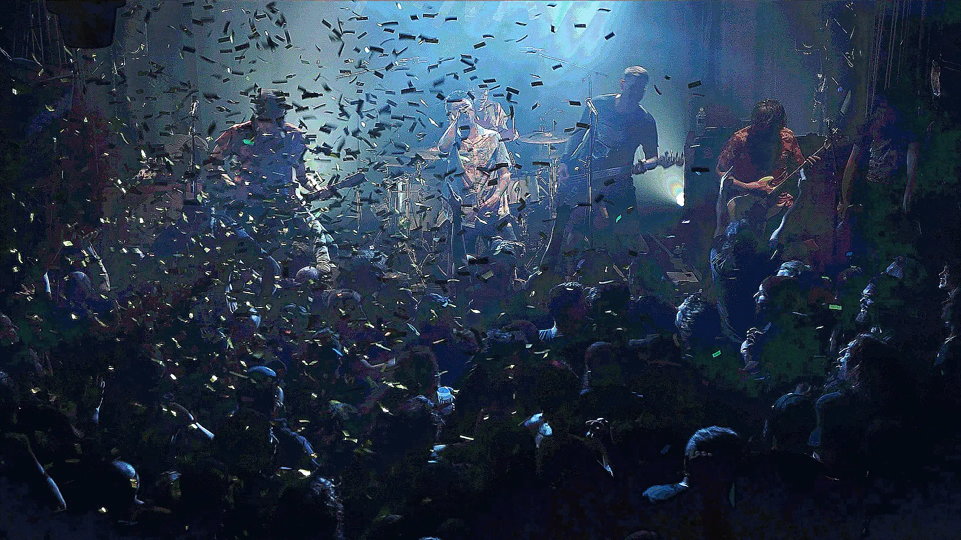 Le groupe Stinky sur scène en pleine performance, entouré d'un public vibrant et d'une pluie de confettis dans une ambiance lumineuse et festive.